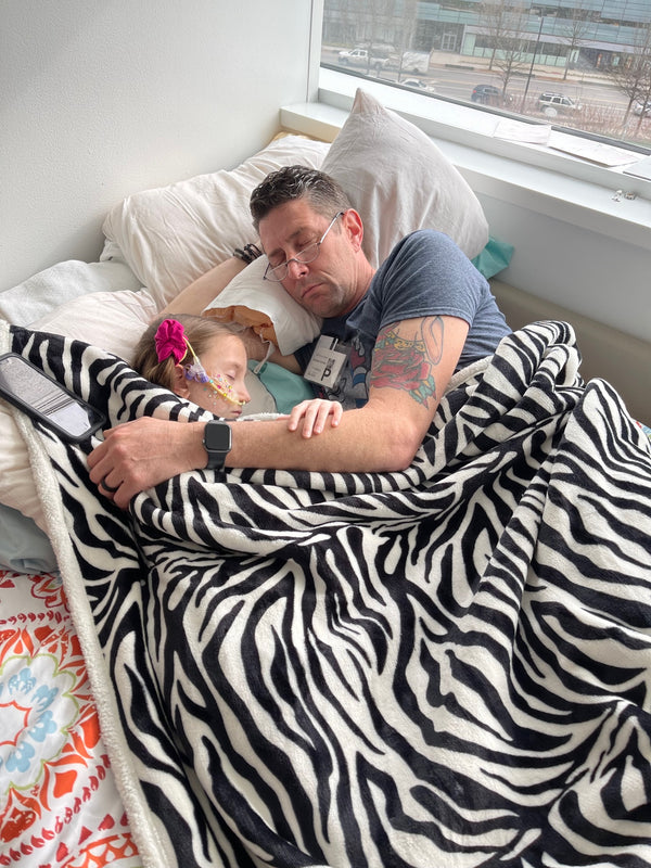 Mike resting beside Sophia during her hospital stay